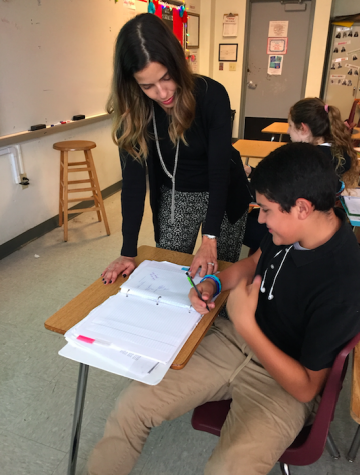Ms. Gonzalez helping a student with their work 