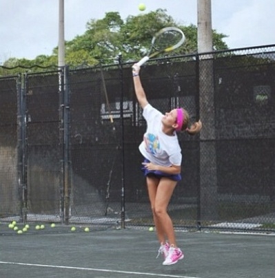 Freshman Sofia Quevedo jumps to hit her serve.