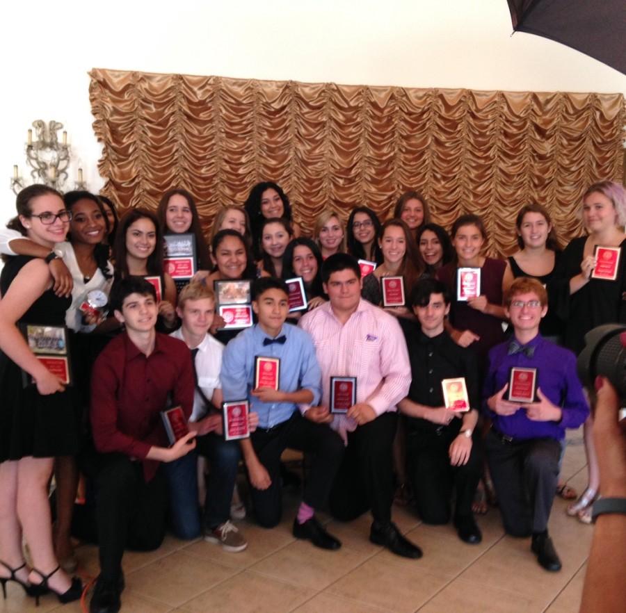 Smiling widely and proudly, CAF&DM award recipients stand together with their plaques.