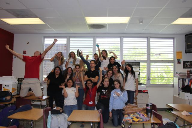 Members of the yearbook staff pose excitedly as they open up the cases of recently arrived yearbooks.