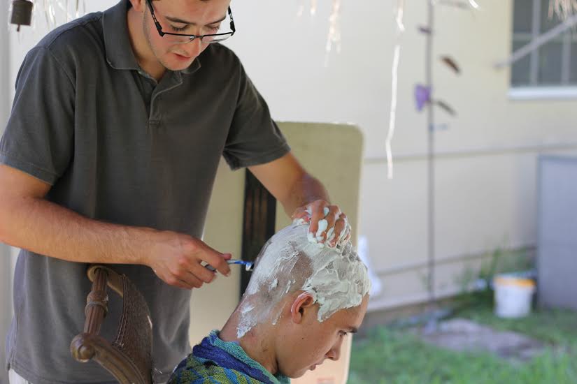 Austin Herrin, the person who initially thought of the idea, shaving the head of Oliver Robles.