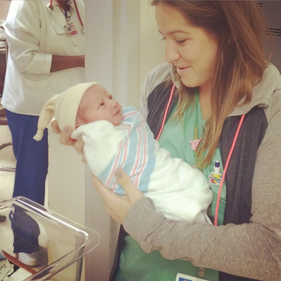 Fletcher holding the first baby delivered in South Florida of 2015.
