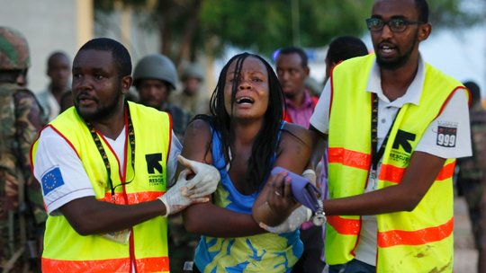 Kenyan authorities help students and citizens out of the University during the shooting.