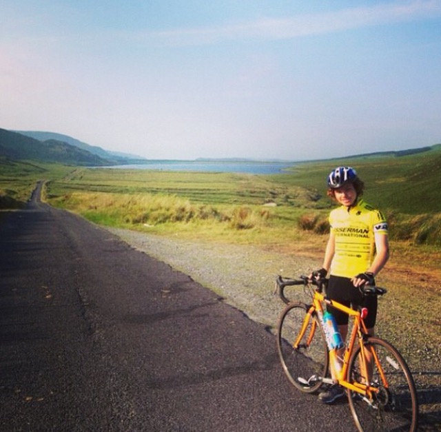Zack Walsh biking through the green terrain of Ireland. 