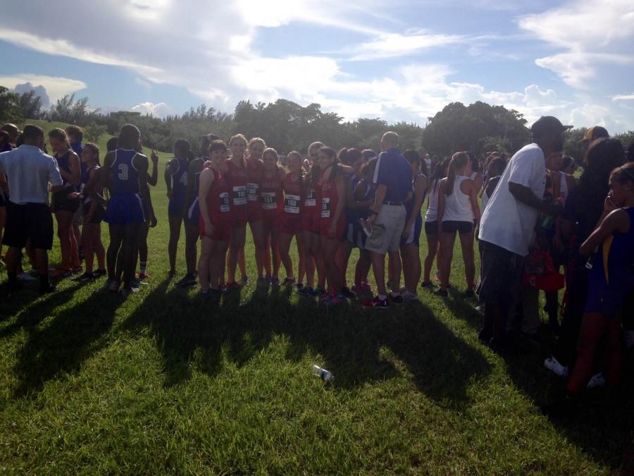 The+girls+cross+country+team+huddle+for+the+meet.+