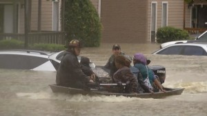 Firefighters have to use boats to rescue people trapped in their homes.