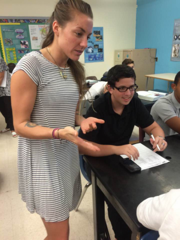Ms. Virginia explaining the classwork to one of her students