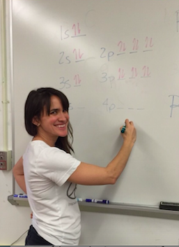 Ms. Kiely explaining a chemistry problem on the board