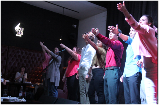 Actors stand together as the play nears its finale.