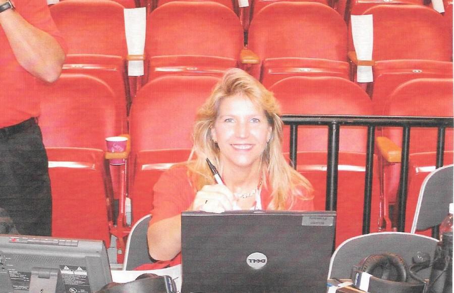 Algebra Teacher Sherry Furnari analyzing game statistics before and during the basketball game. 