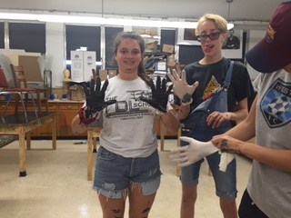 Sophomore Kelly Hanley and junior Bryan Tucker get their hands dirty as the painting commenced.