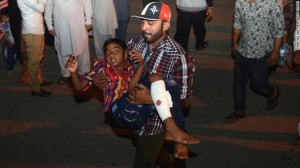 A man carries an injured child from the scene. 