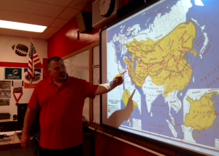 Mr.Miller explaining map with his students, doing what he loves.