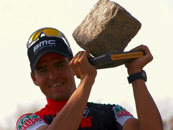 Greg Van Avermaet hoists the ceremonial cobblestone trophy after winning Paris Roubaix.