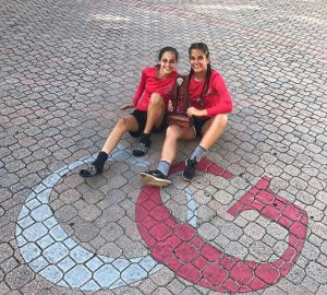 Flag Football Captain, Gabriela Morales, and teammate, Natalie Puntonet, together holding the award the team received for being the Districts Runner-ups.  