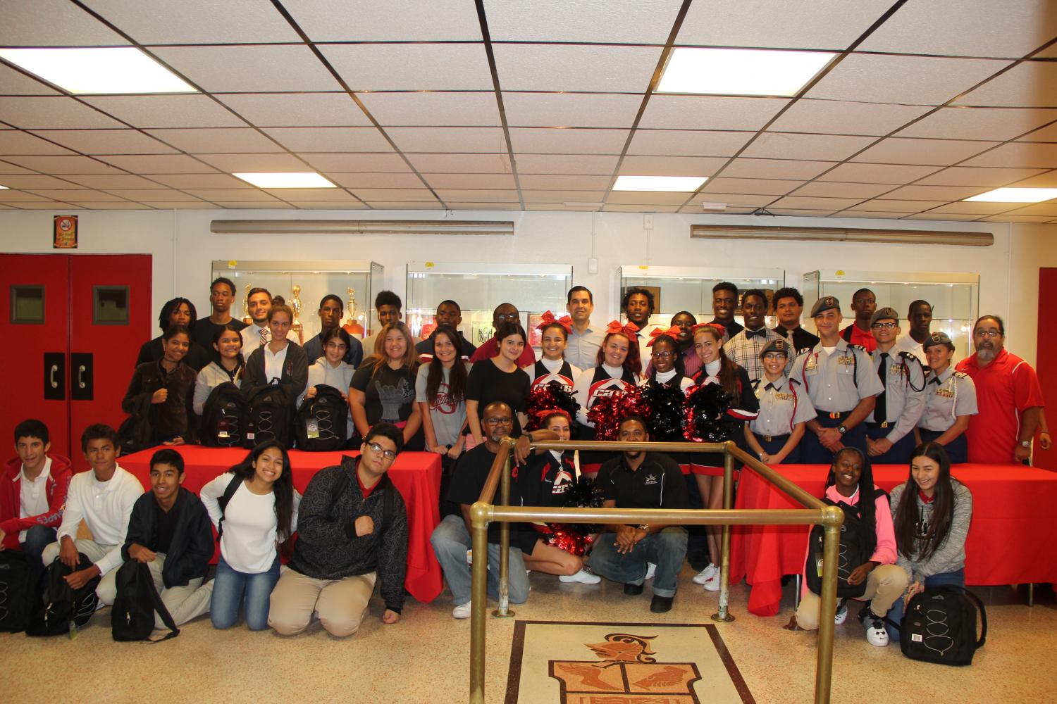 Gables students smile for a picture with Commissioner Lago in the auditorium lobby.