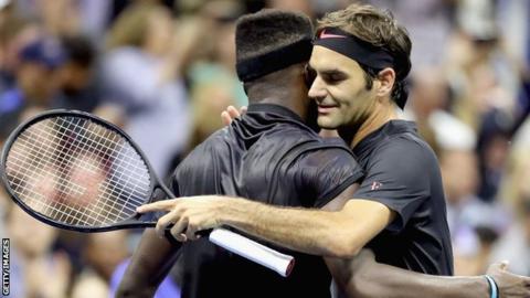 Frances Tiafoe (left) and Roger Federer embrace after Federer's hard-fought victory over 5 sets.