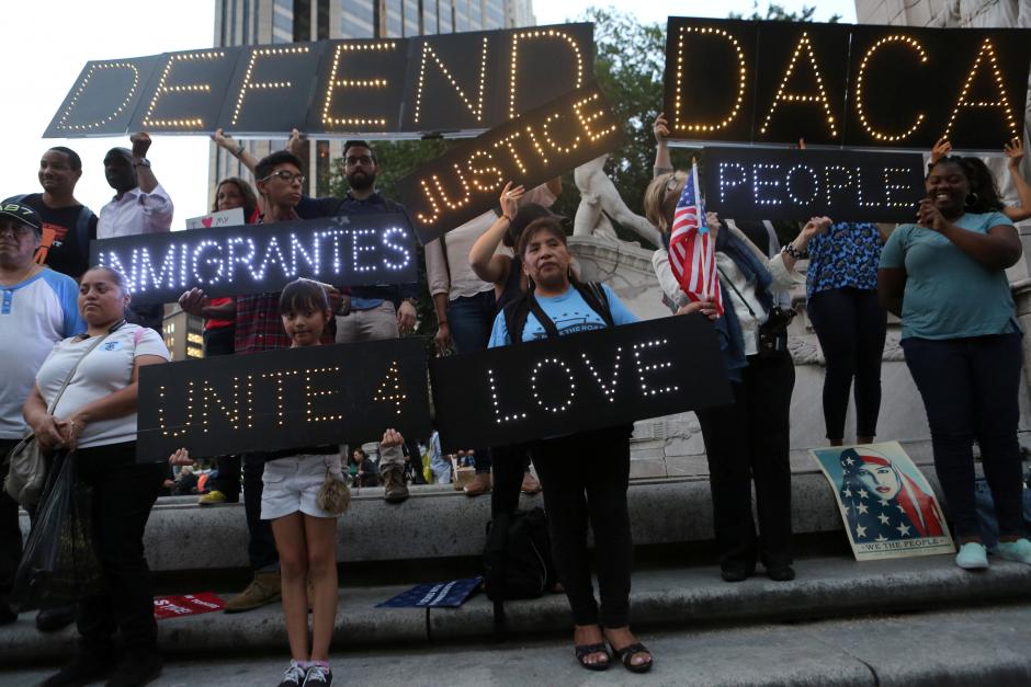 FILE PHOTO - People hold signs against U.S. President Donald Trump's proposed end of the DACA program that protects immigrant children from deportation at a protest in New York City, U.S., August 30, 2017. REUTERS/Joe Penney