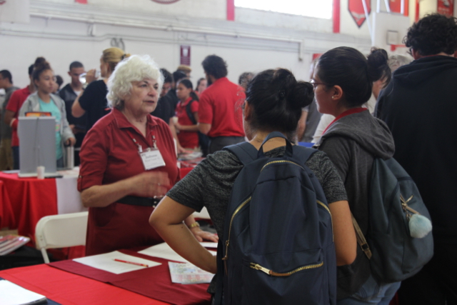 Students speak with a representative from Harvard University.