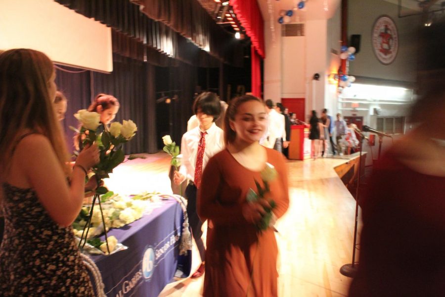 IB Junior students walk across the stage to get pinned.