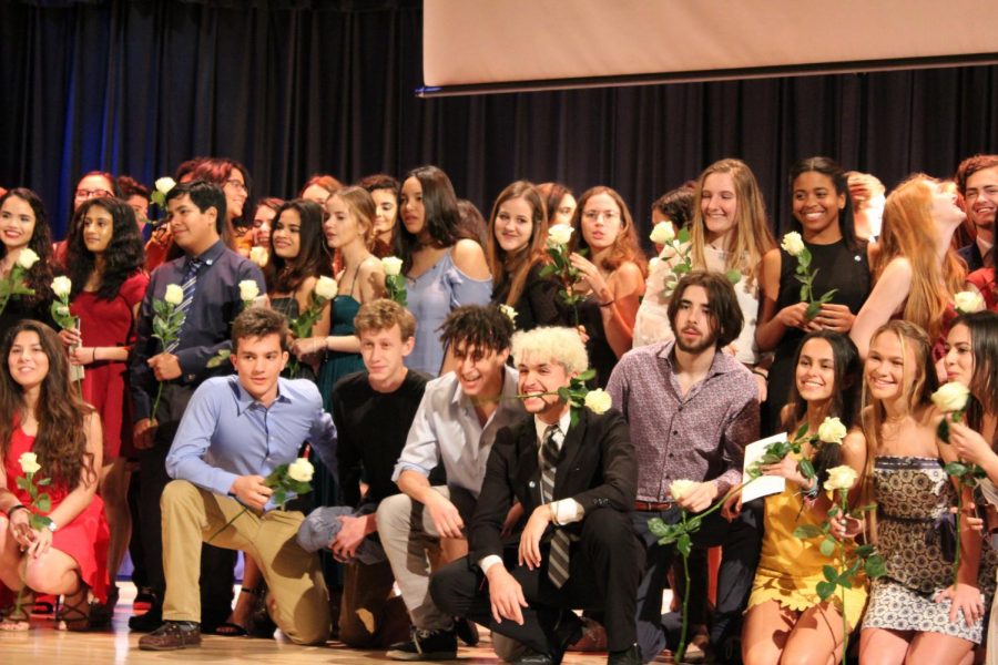 Newly+inducted+IB+students+pose+for+a+group+photo+on+stage.