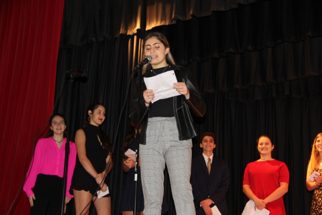 IB senior Emma Berberian congratulates the class in Armenian.