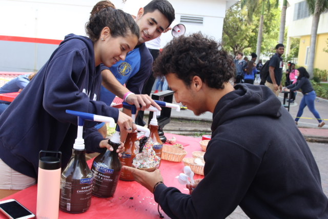 Senior Alain Guerra piling up the toppings on his sundae.