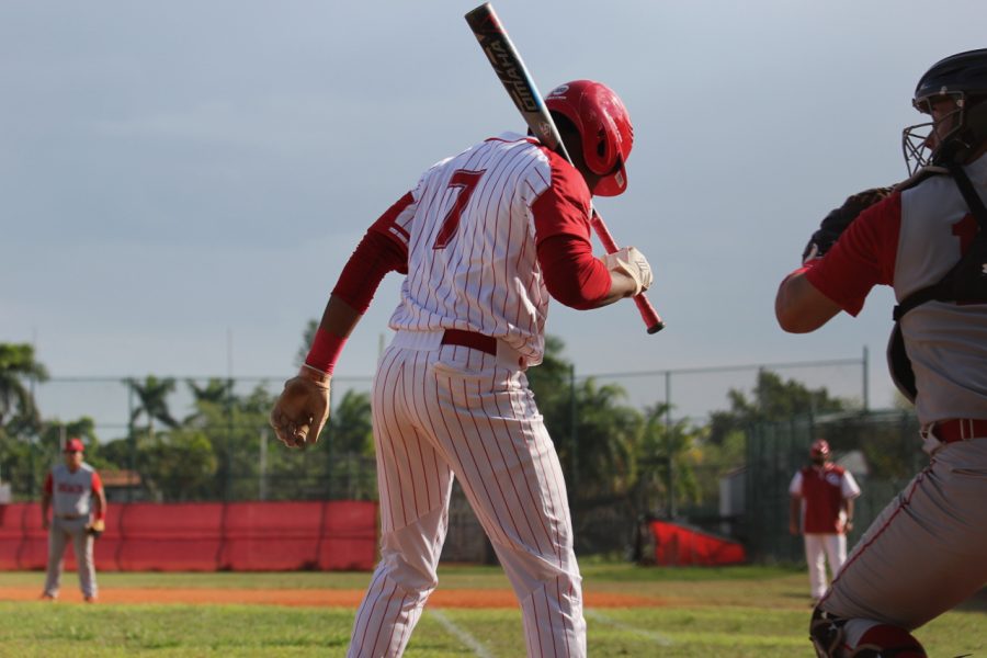 Luis Espinal steps into the batter's box, anticipating the incoming pitch.