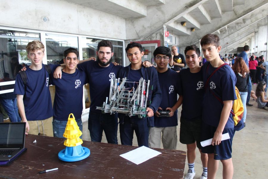 El club de ingeniería mostrando orgullosos su creación mientras sonrien para una foto. 