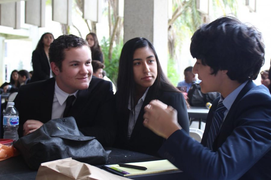 Sophomore Jesse Zambrano and junior Alain Perez discuss with delegates possible resolutions for their committees. 