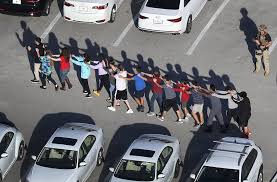 Estudiantes de la secundaria ubicada en Parkland siendo movidos en cadena de forma segura hacia donde se encontraba el Centro de control y os carros de bomberos.