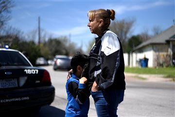 Isaac Machado se esconde detrás de su sombrero contra su madre, Dolores, fuera de la escena de una explosión en la calle Galindo en Austin, Texas.