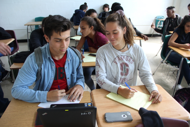 Two students cheating off of each other.