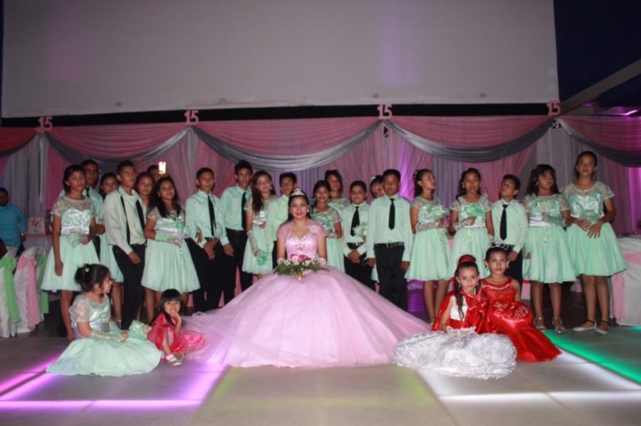 Dayanesi Martinez, a senior at Coral Gables. posing for a picture with her quinces court in Nicaragua while celebrating her quinces.