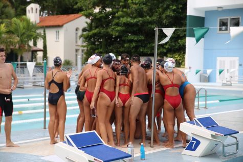 The Coral Gables Cavaliers Swimming Team huddles together in preparation for their swimming meet.