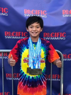 Young Clark Kent Apuada poses with his medals at the end of the swim meet. 