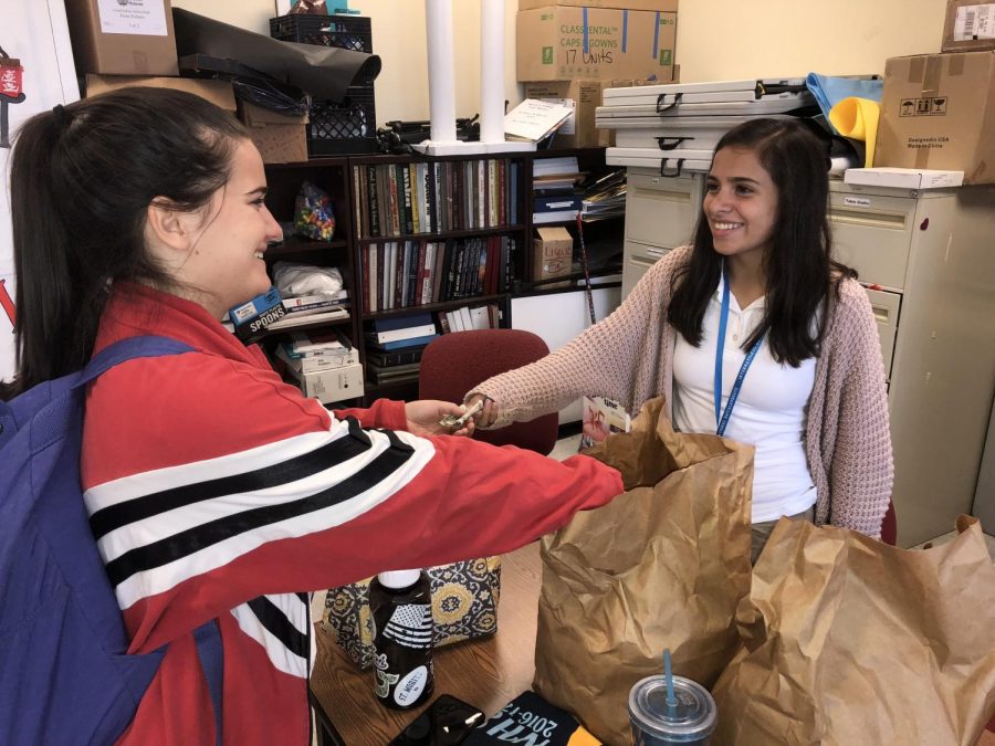 Senior Dominique Babin purchases a delectable ring of bread from junior Jimena Romero.