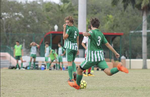 August Field prepares to strike the soccer ball as he runs up the field.