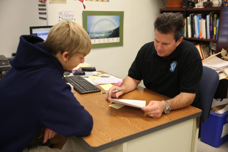 Psychology teacher, Mr.Nelson, reviews an Extended Essay with a student.