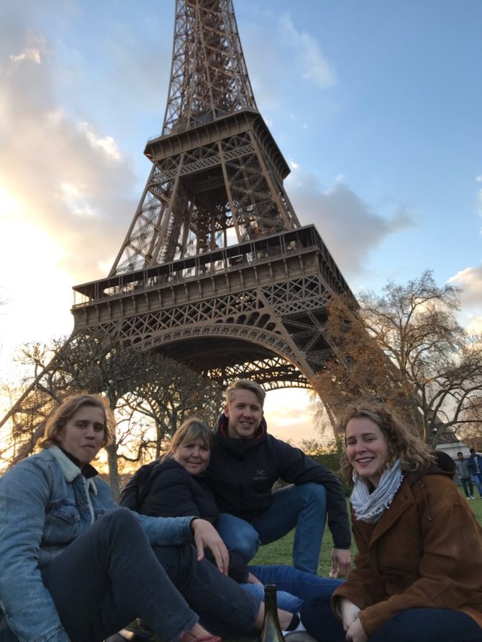 Sutton sitting with his family underneath the Eiffel tower.