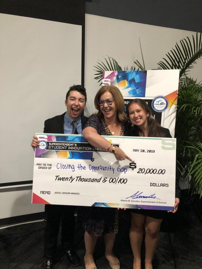 Ochoa and Estrada proudly stand with Ms. Suarez, holding their prize money.