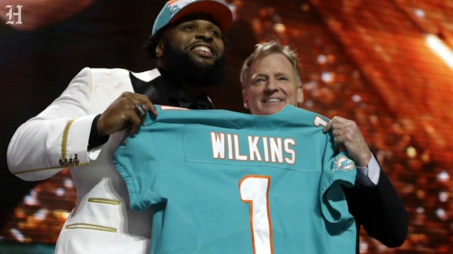 NFL Commissioner Roger Goodell presents the number 13 overall pick, Christian Wilkins, with his Miami Dolphins jersey.