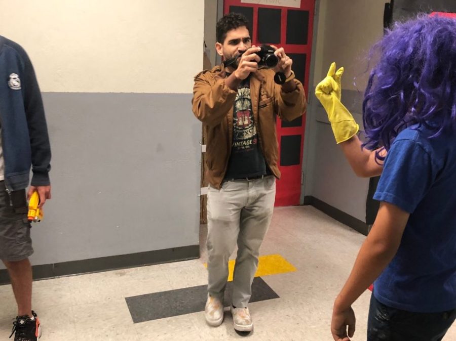 Mr. DE Armas takes picture of a student dressed in a purple wig