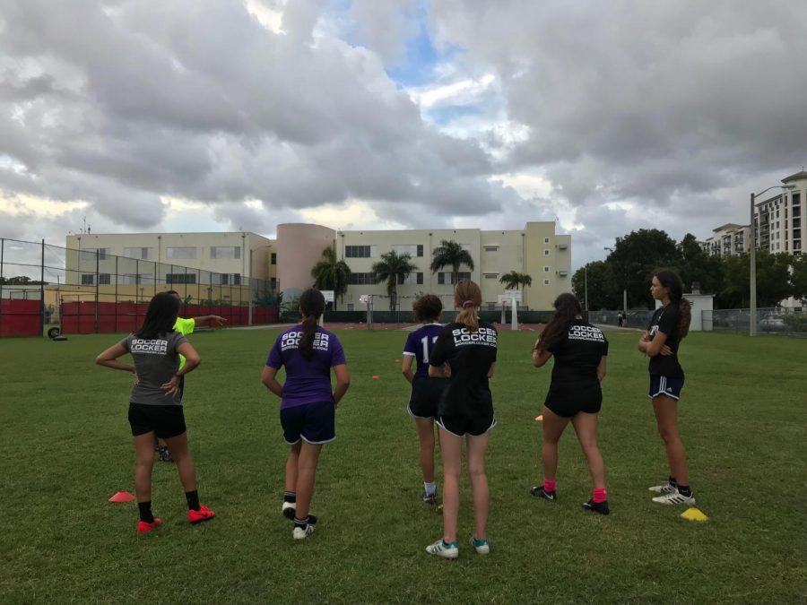 The Miami Tempo soccer team prepares to run a drill on the field at Coral Gables Senior High School.