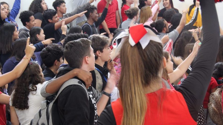 The students pointing and singing the Alma Mater.