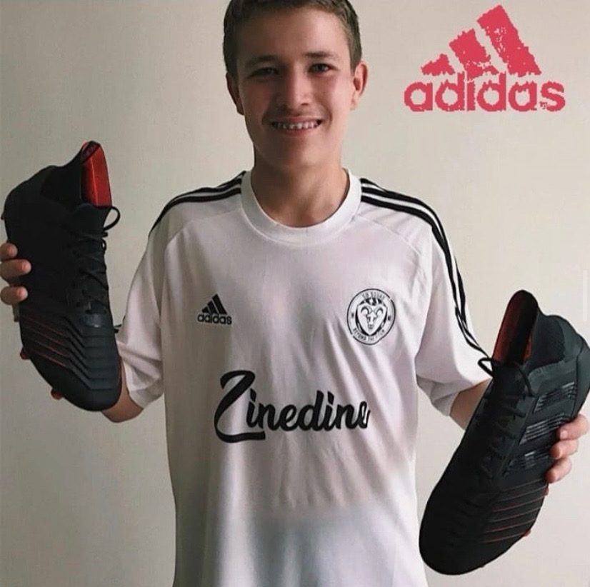 Marco+Lund-Hansen+poses+for+a+picture+while+holding+cleats+gifted+to+him+by+Sports+Direct.