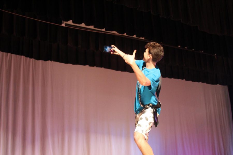 Mr. MUN takes a selfie with the cheering crowd behind him.