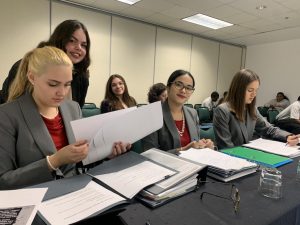 Gables' mock trial team prepares its case files and evidence for their presentations as they wait for the trial to start.