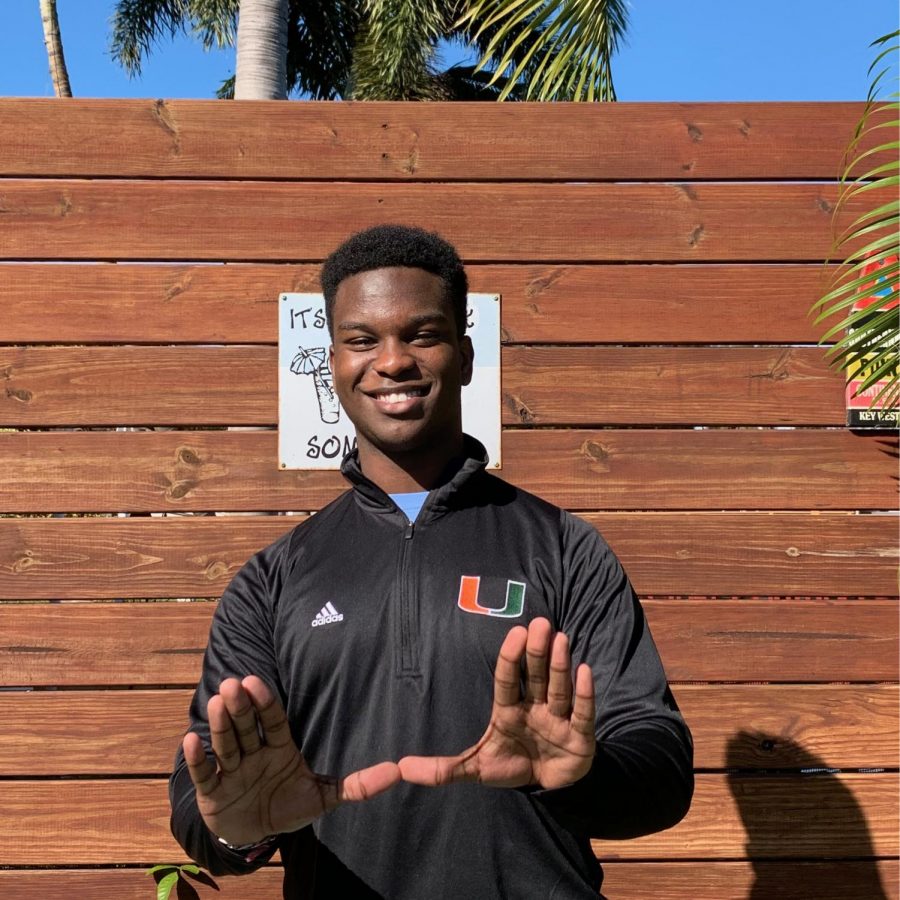 Rodney Michel poses with his new University of Miami gear, adding in the signature University of Miami U hand symbol.