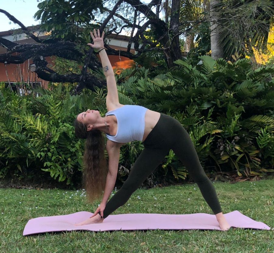 Senior Marina Tischenkel practicing her triangle pose outdoors